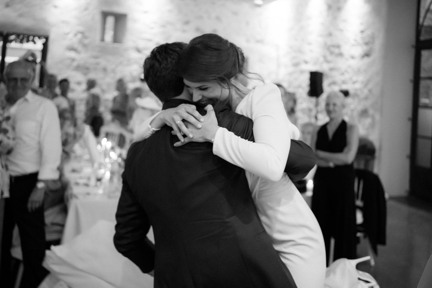 Black and white candid moments of celebration during a wedding reception.