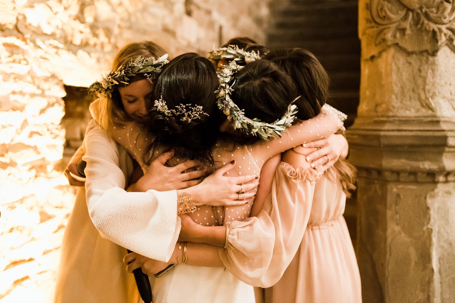 Intimate moments captured during a wedding celebration in a warmly lit stone venue.