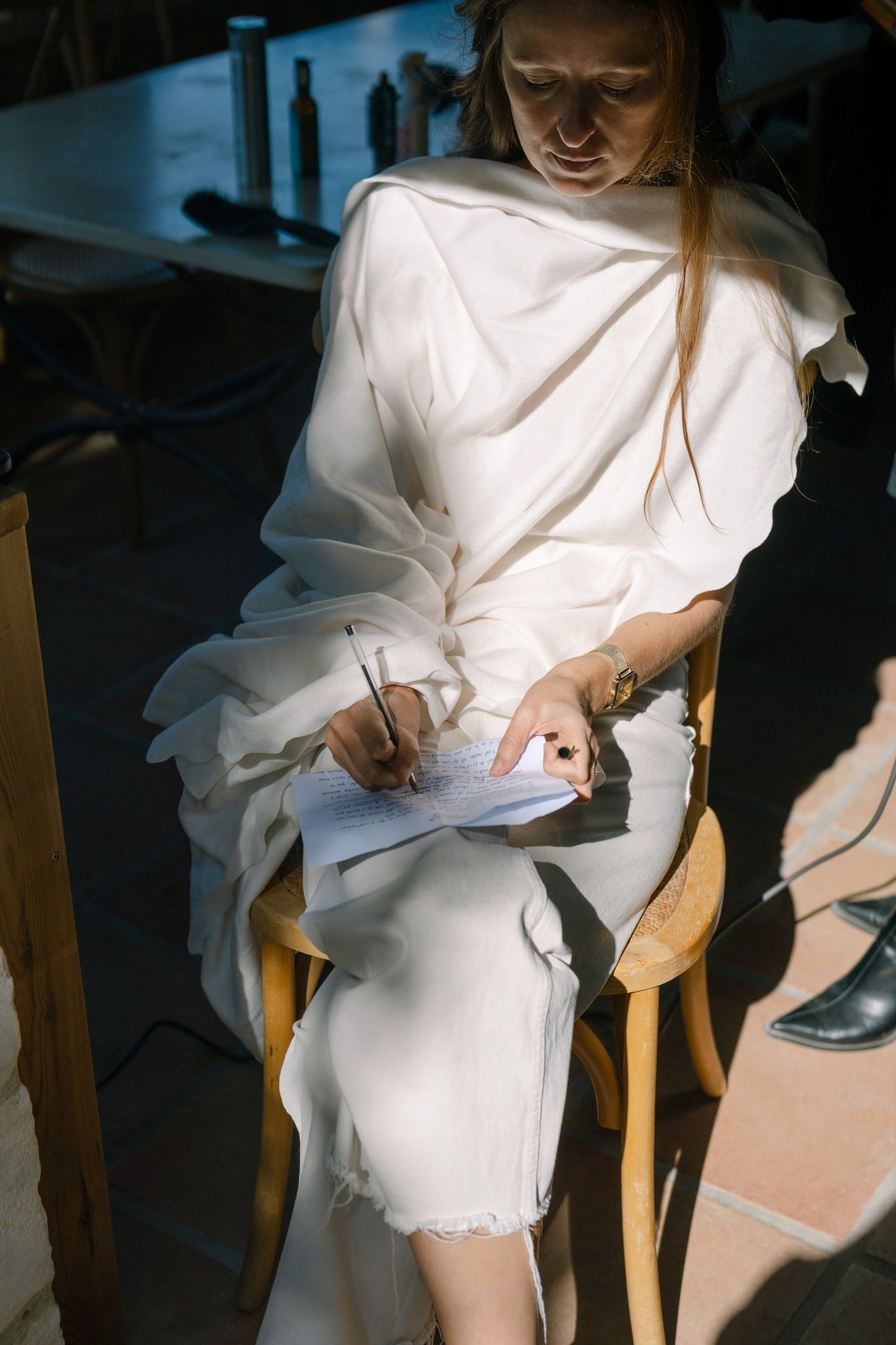 A person in a flowing white dress sitting in a chair, shown in a sequence of artistic photos.