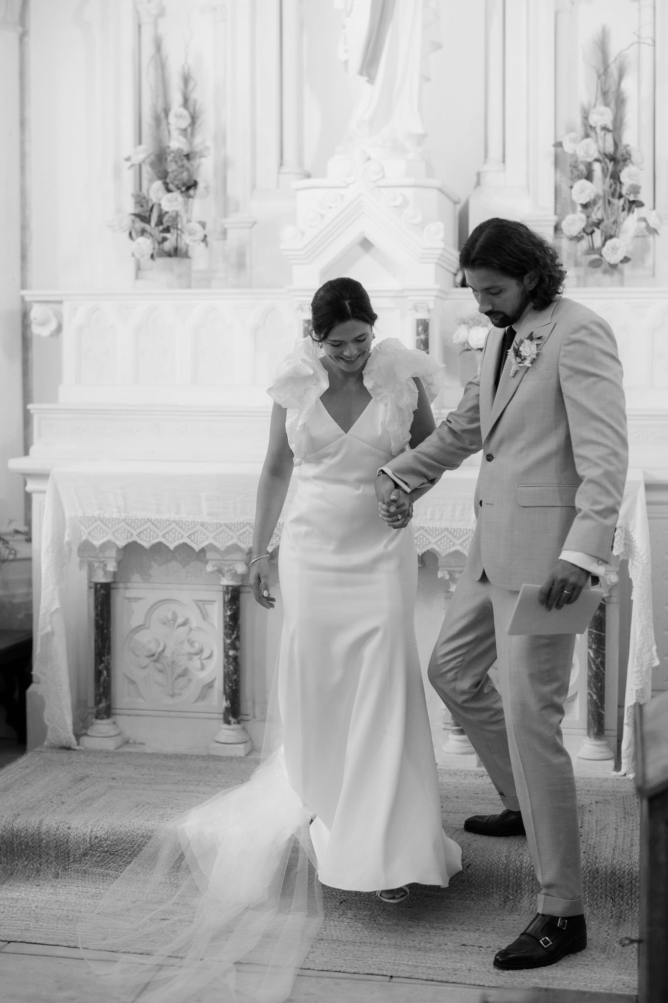 Series of black and white photos showing tender moments between newlyweds in church.