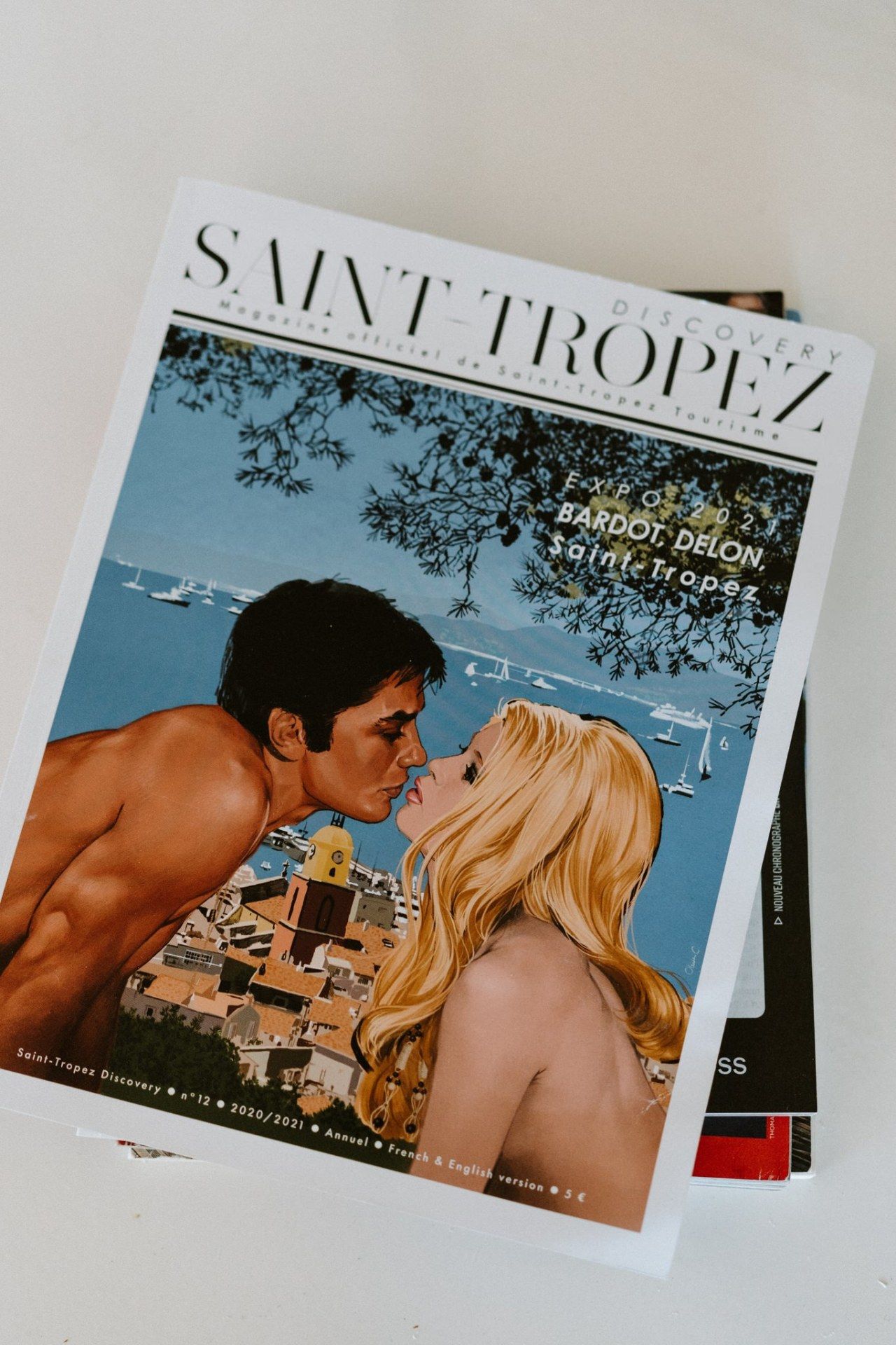 A vintage-style Saint Tropez magazine cover showing an artistic illustration of a romantic scene.
