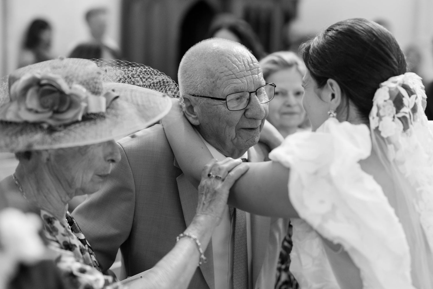 Series of candid black and white photos showing wedding guests sharing emotional moments.