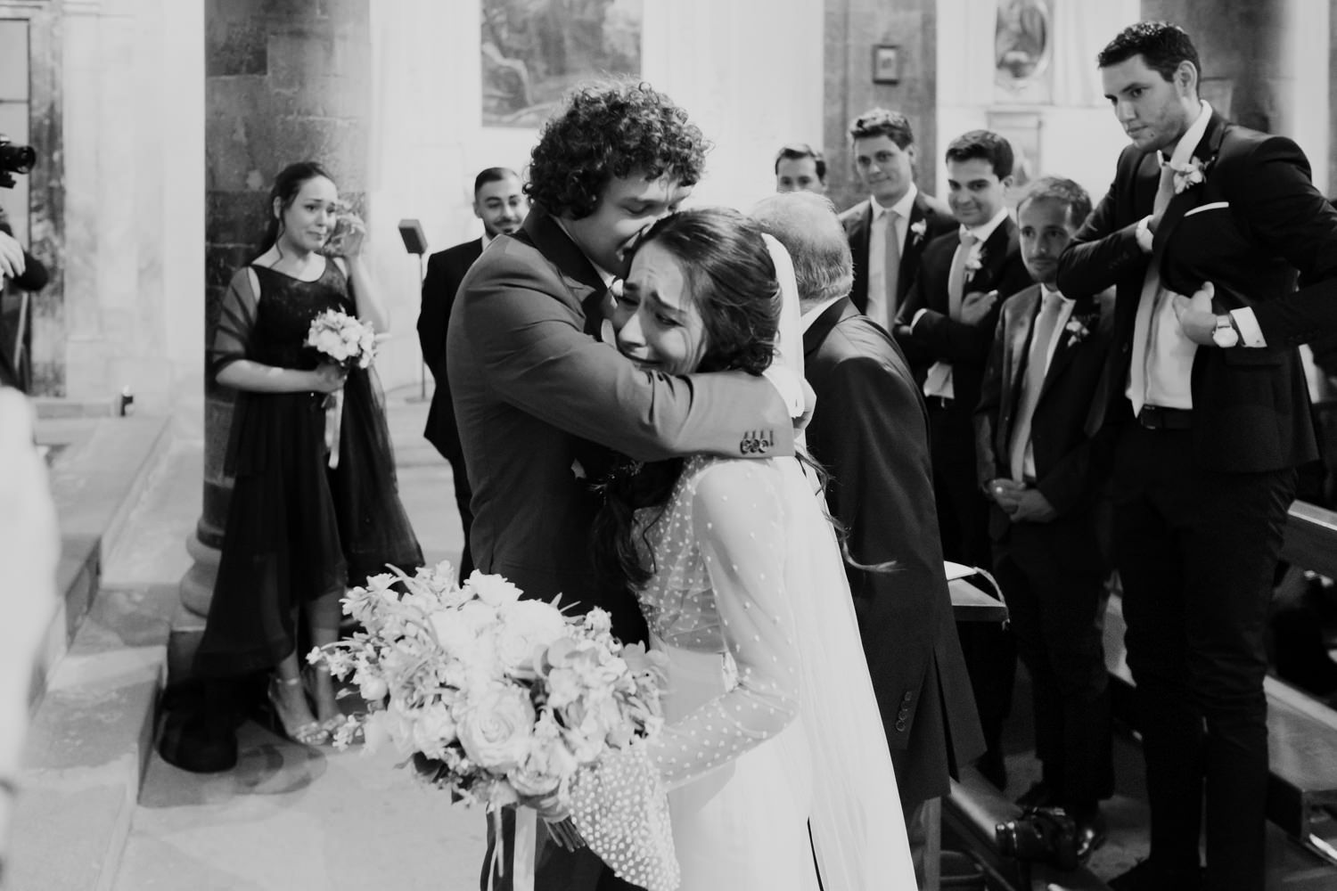 Black and white photo of wedding celebration in an elegant church setting.