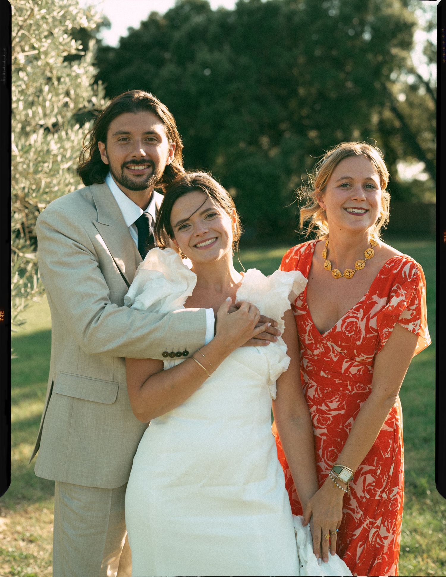 Four candid wedding photos show joyful moments between a bride in white and guests in a sunny outdoor setting.