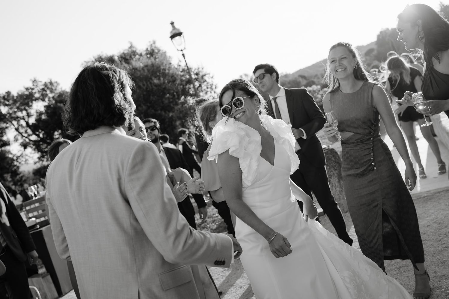 Wedding guests dancing and celebrating during an outdoor reception.