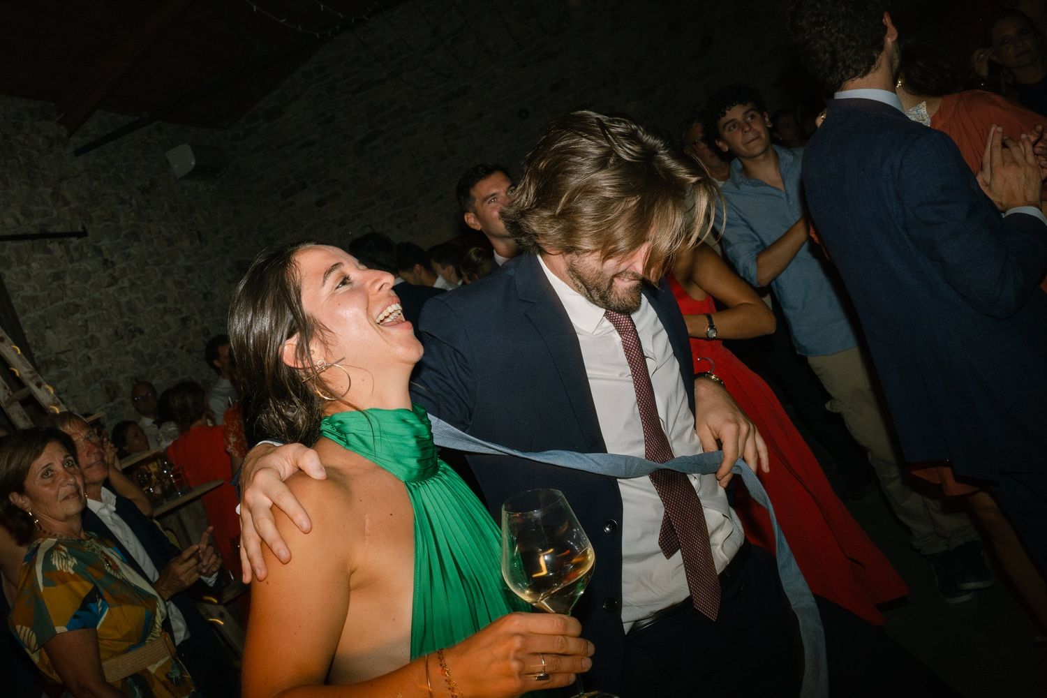 Lively dance floor scene with guests dancing in colorful attire during evening celebration.