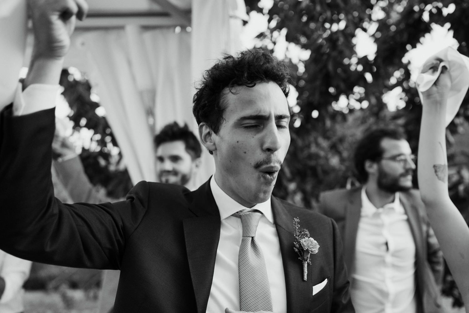 Black and white photo of wedding guests celebrating during speeches.