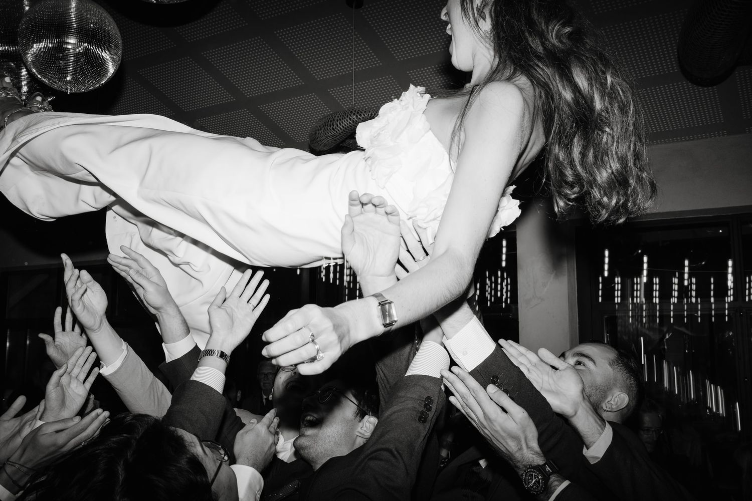Black and white photos capture energetic dancing moments at a wedding celebration.