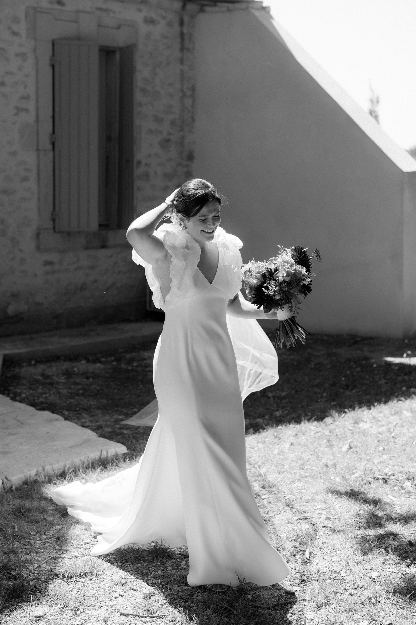Black and white series of a bride dancing and twirling in a sunlit outdoor setting.