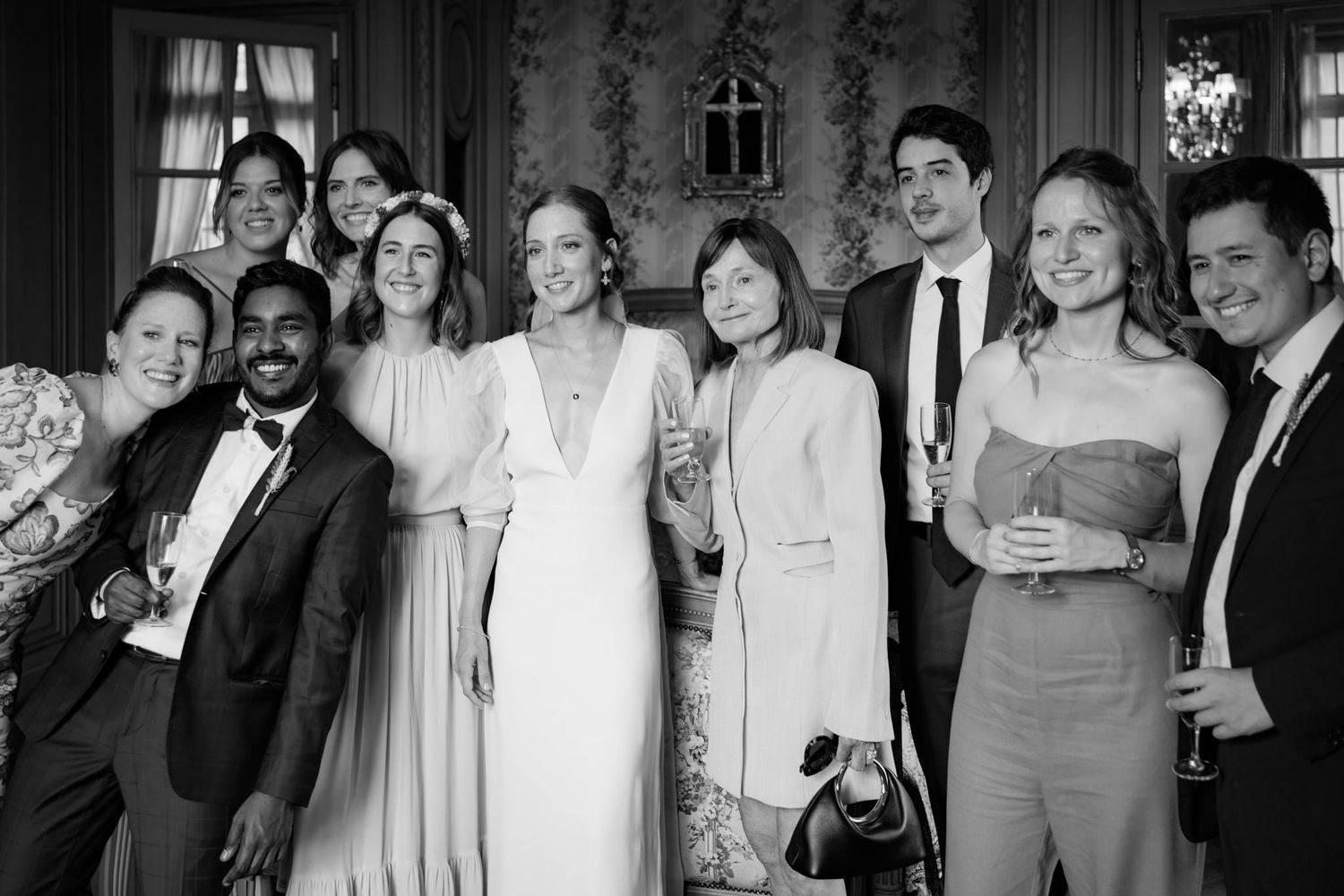 A black and white panorama of wedding guests gathered together for a group photo.