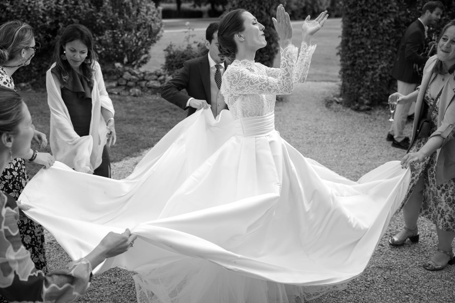 A flowing white wedding dress being twirled in an outdoor setting.