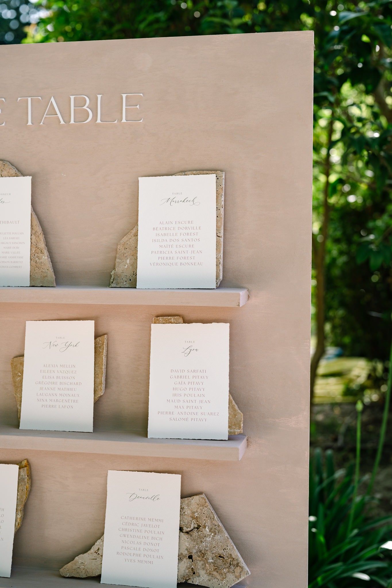 Wedding seating chart display with white cards arranged on a neutral backdrop.