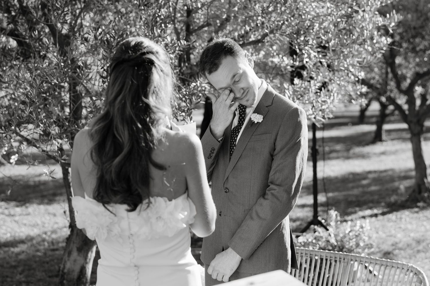 Black and white photos show tender moments between newlyweds in an olive grove.