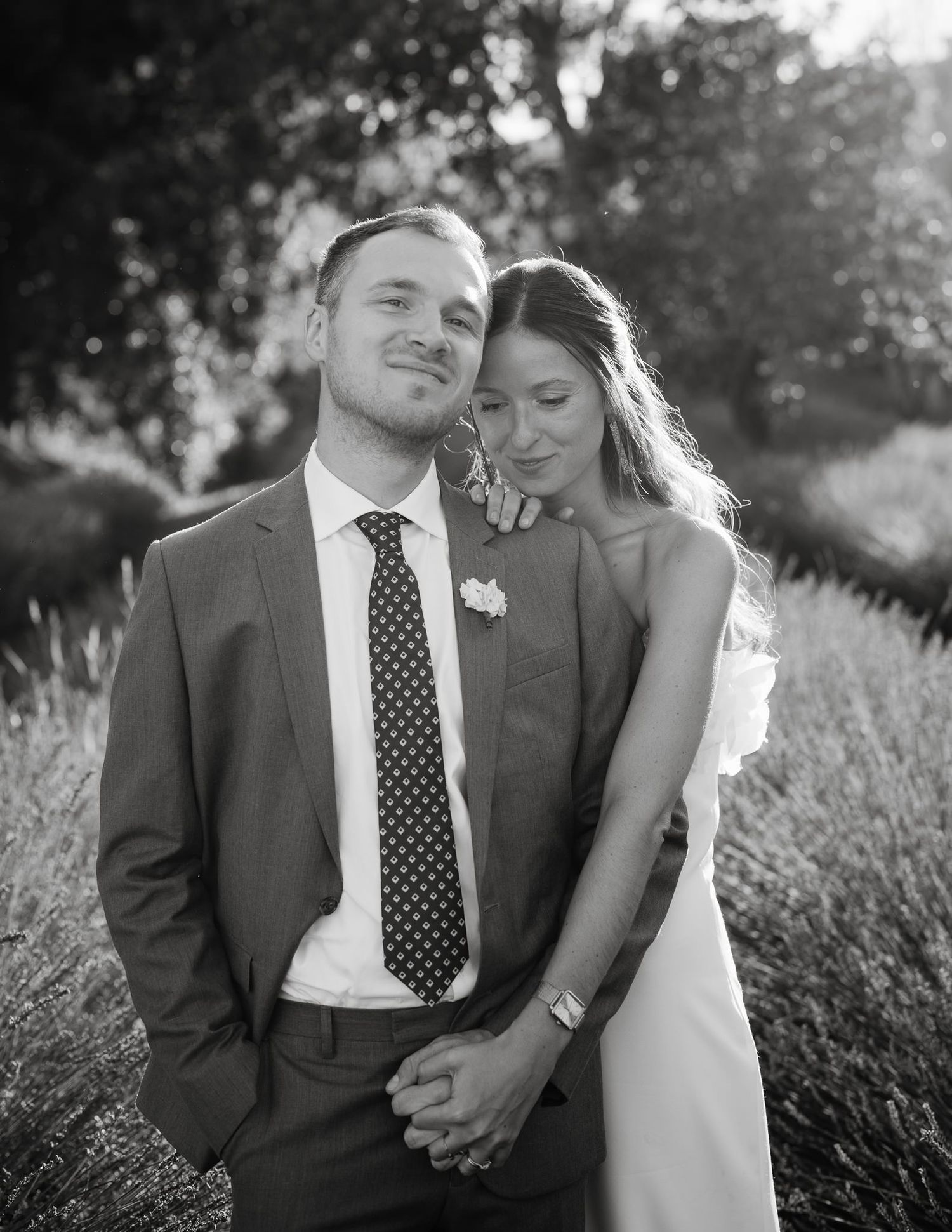 Romantic wedding couple embraces in a lavender field during golden hour sunset.