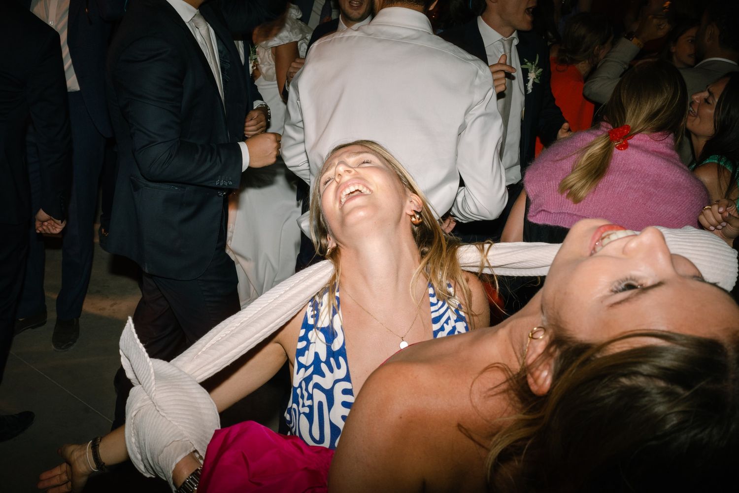 Energetic dance party with guests celebrating at a wedding reception.