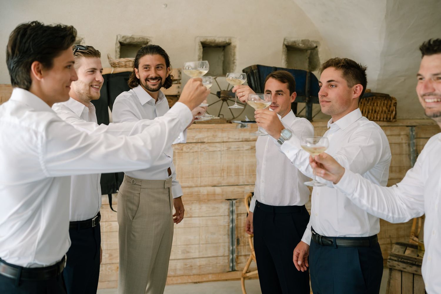 Group in white shirts raising glasses in celebratory toast.