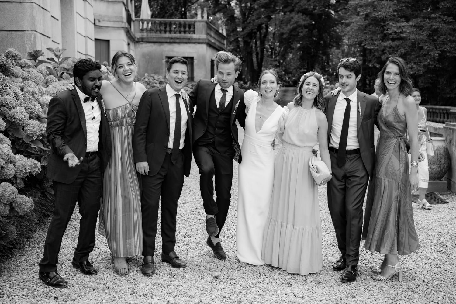 Wedding party poses for formal group photos outdoors in formal attire.