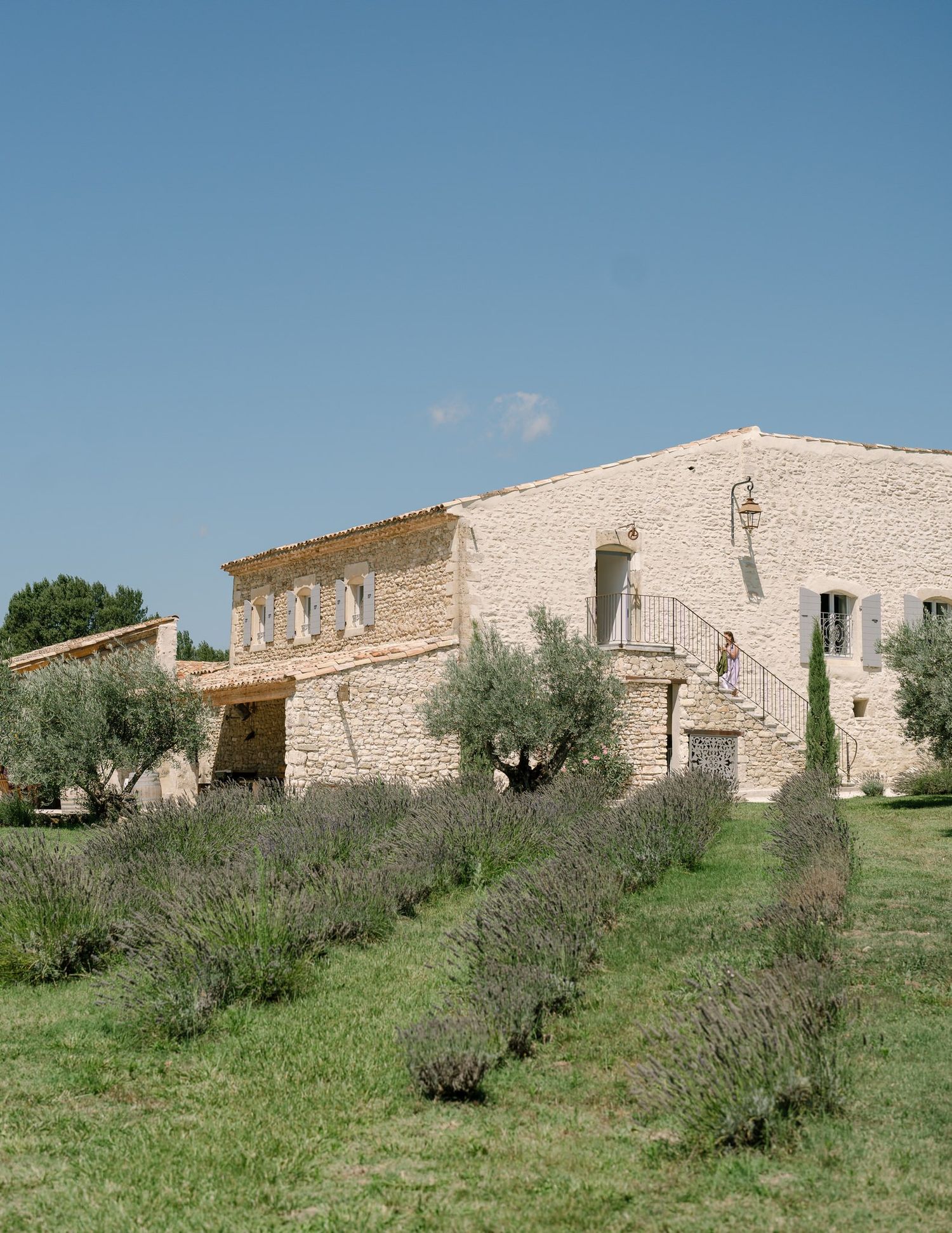 Stone buildings and olive trees on a Mediterranean hillside.