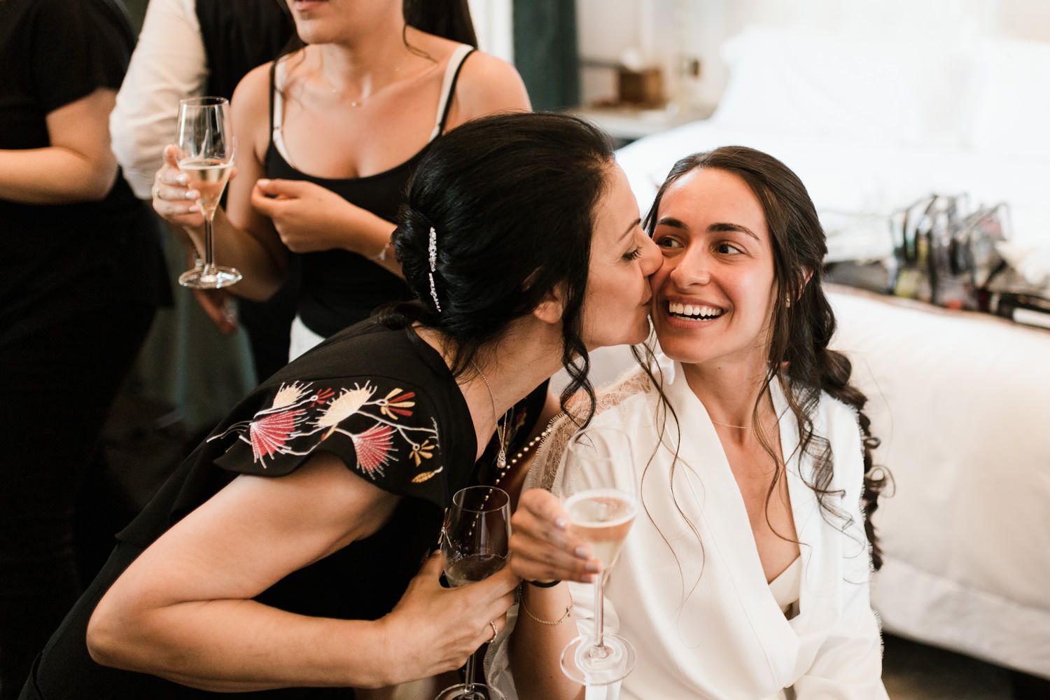 A candid moment of celebration with wine glasses and laughter at a wedding reception.