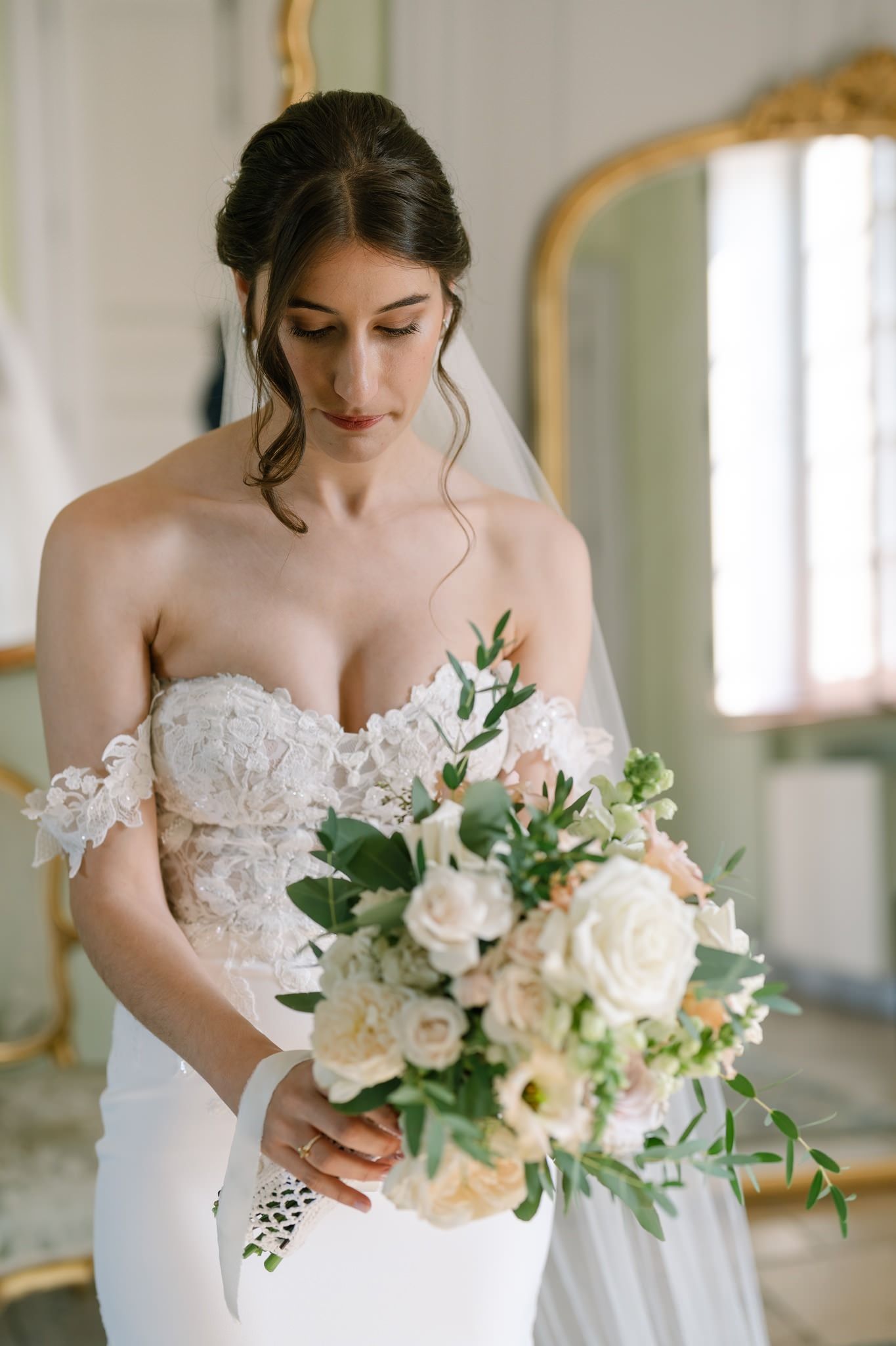 Wedding dress detail with delicate lace bodice and soft white bouquet.