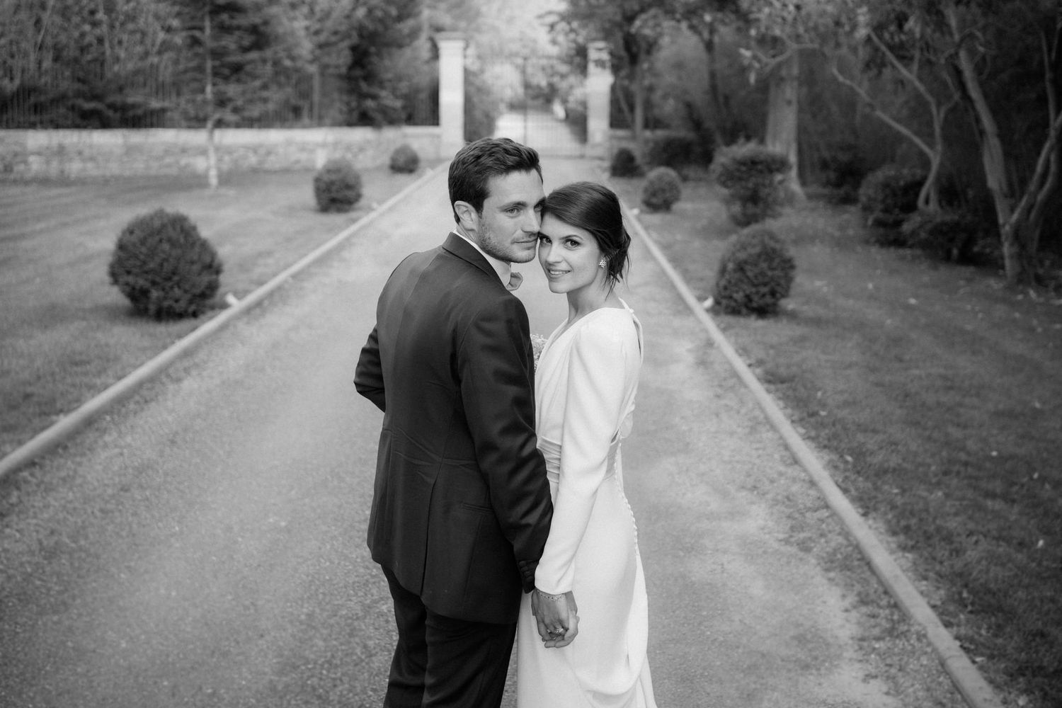 Romantic black and white wedding photography captured on garden pathways.