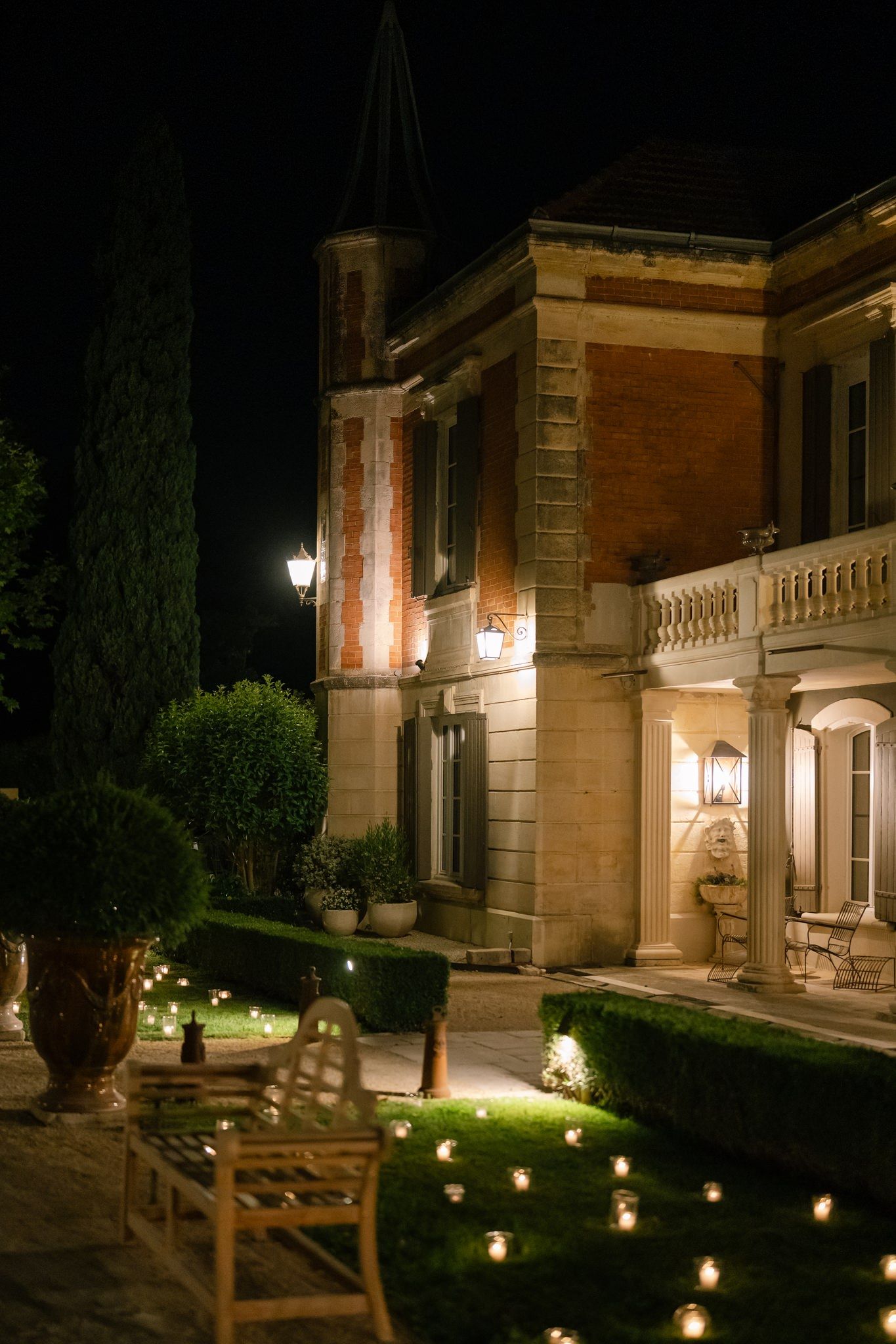 Historic mansion exterior illuminated at night with warm lighting and landscaped grounds.