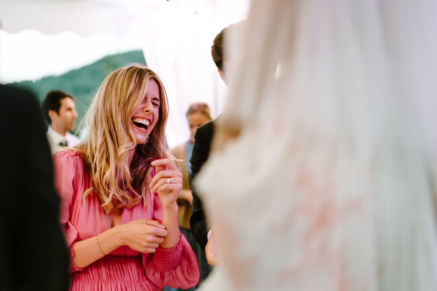 Candid moments of guests laughing and enjoying the wedding reception.