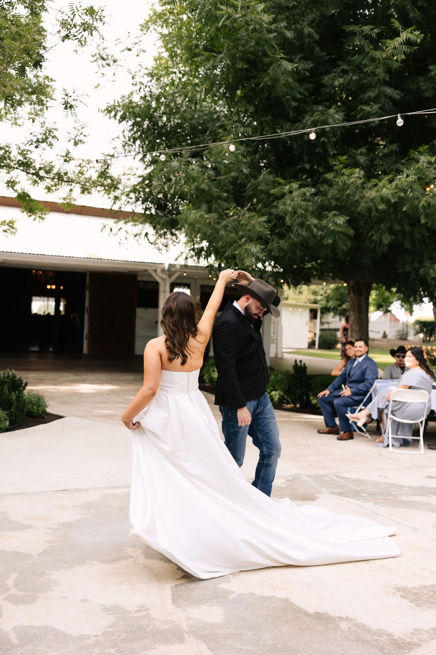 A series of five wedding photos shows a couple twirling and dancing together on an outdoor patio surrounded by trees.