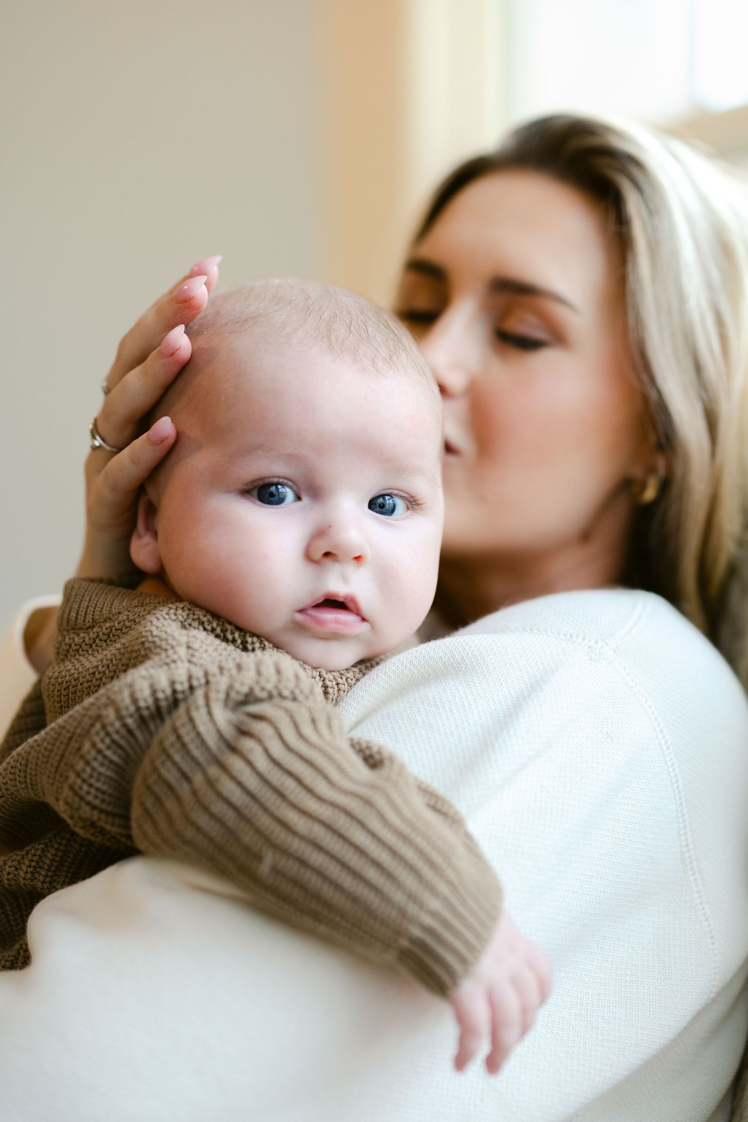 A tender moment between parent and baby as they share a loving embrace in soft natural light.