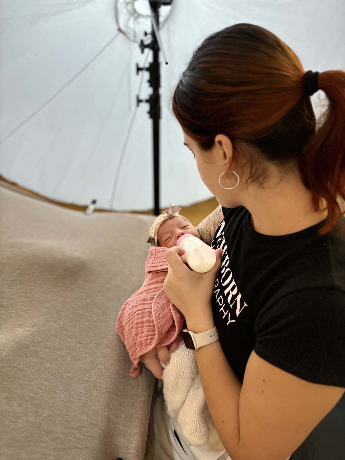 Fotografa en Tampa Laura Palacio feeds a wrapped in a pink blanket dur