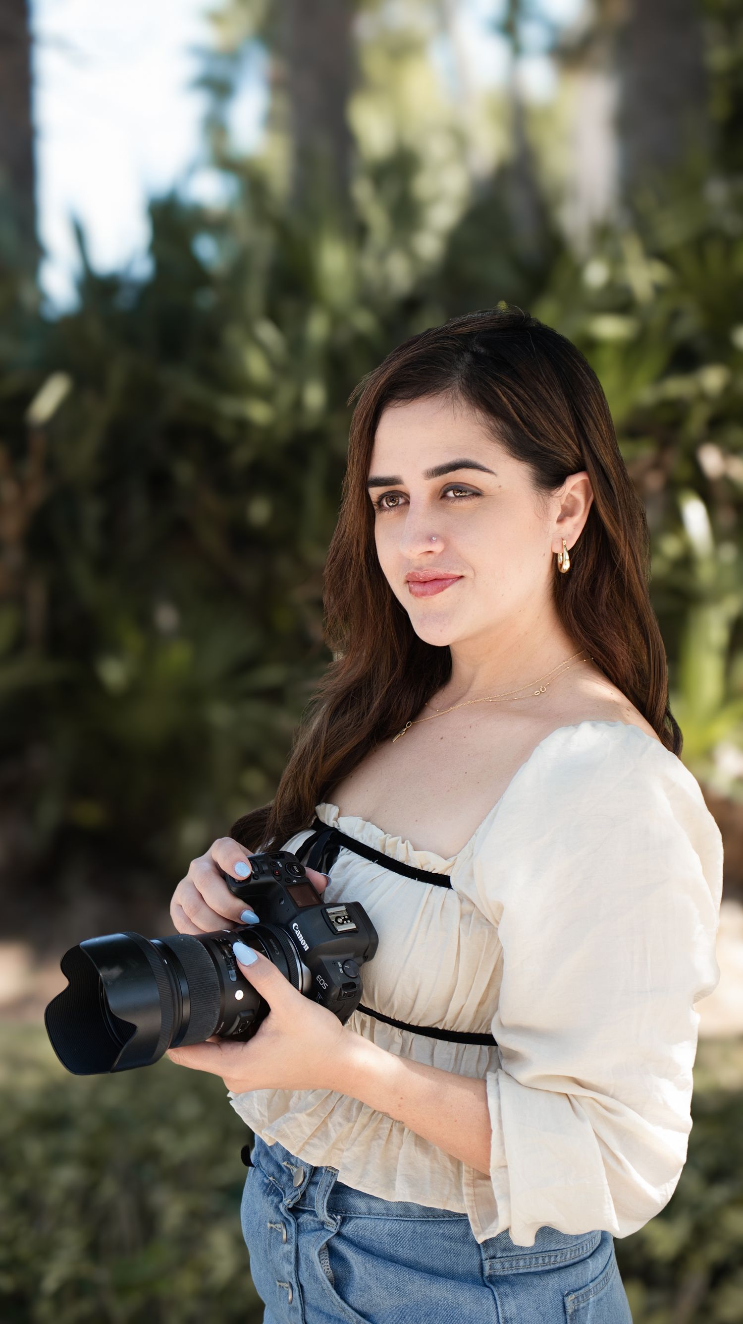 Fotógrafa en Tampa Laura Palacio sosteniendo una cámara en un lugar de Tampa