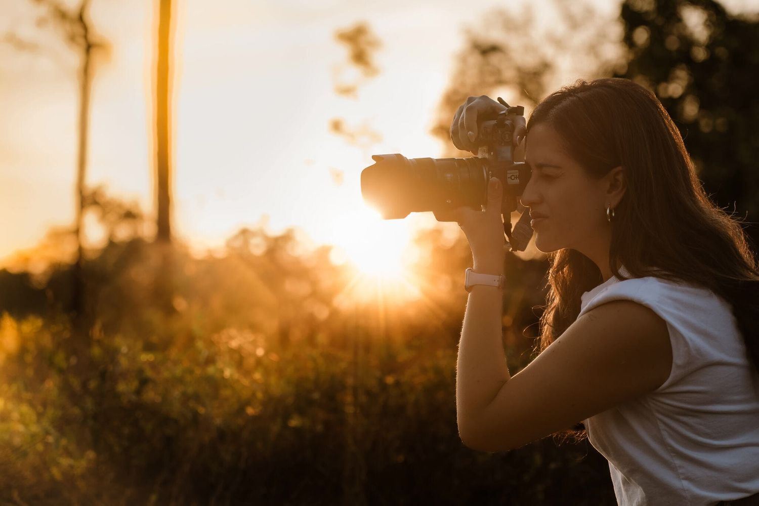 Photographer captures stunning golden hour shot while using professional camera equipment in nature setting.