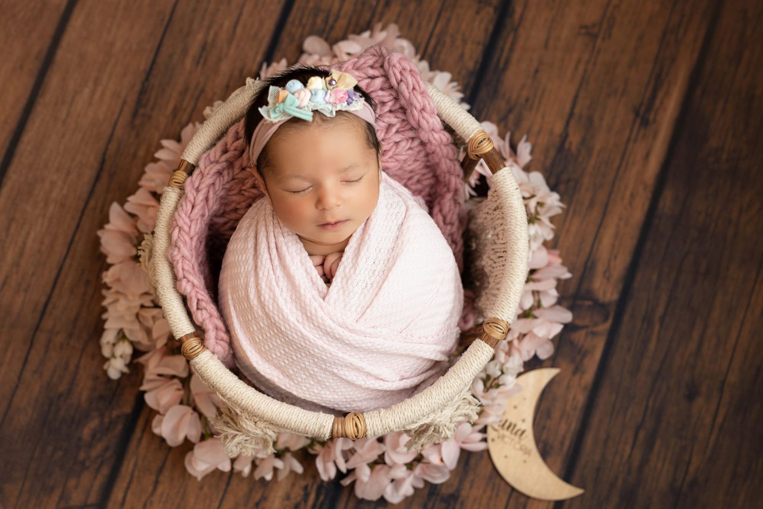 bebe recien nacido en cesta vincha flores rosas fotografia newborn en tampa sesion 2024