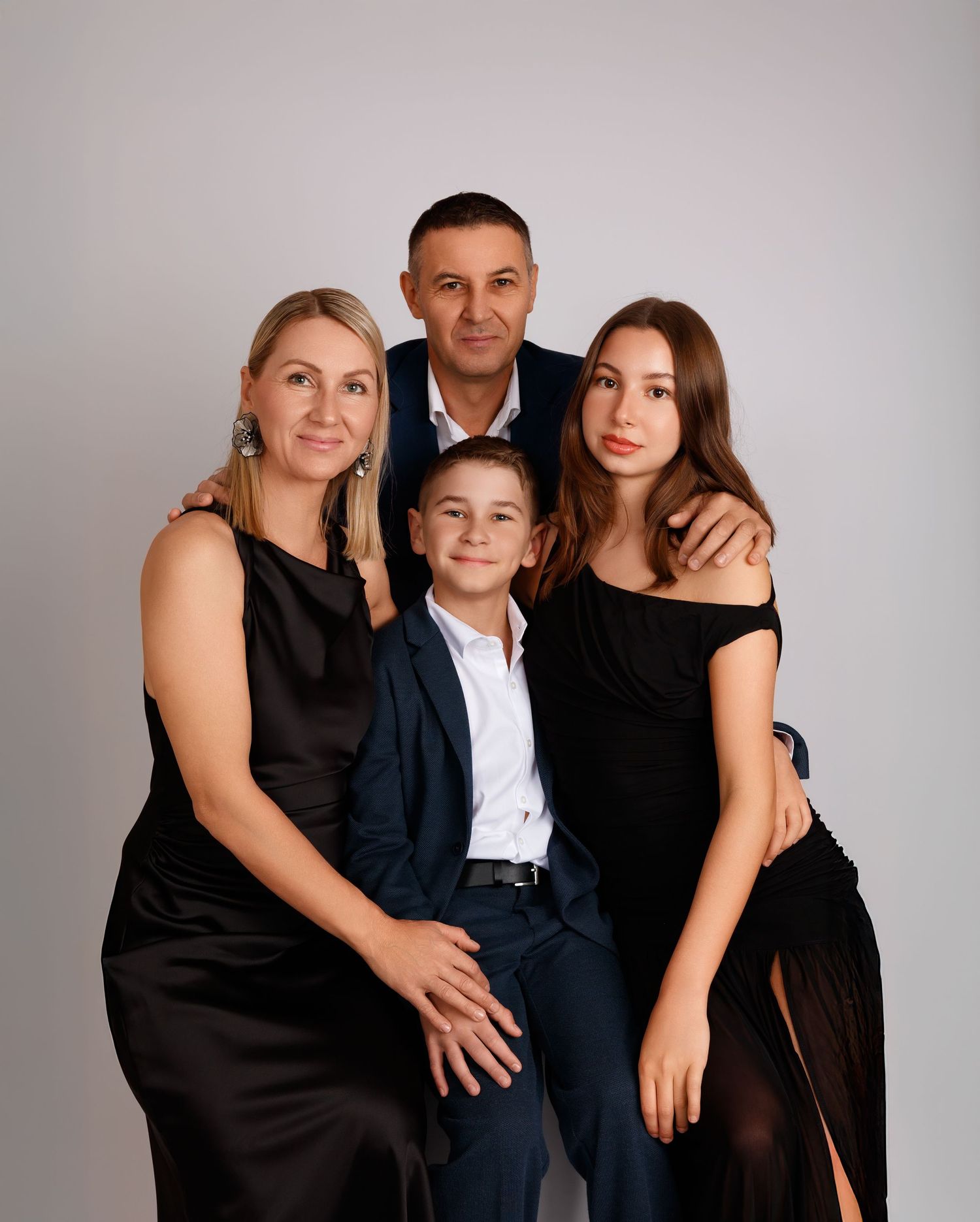 Family photography in a Laval studio — family of four in elegant black and navy outfits.