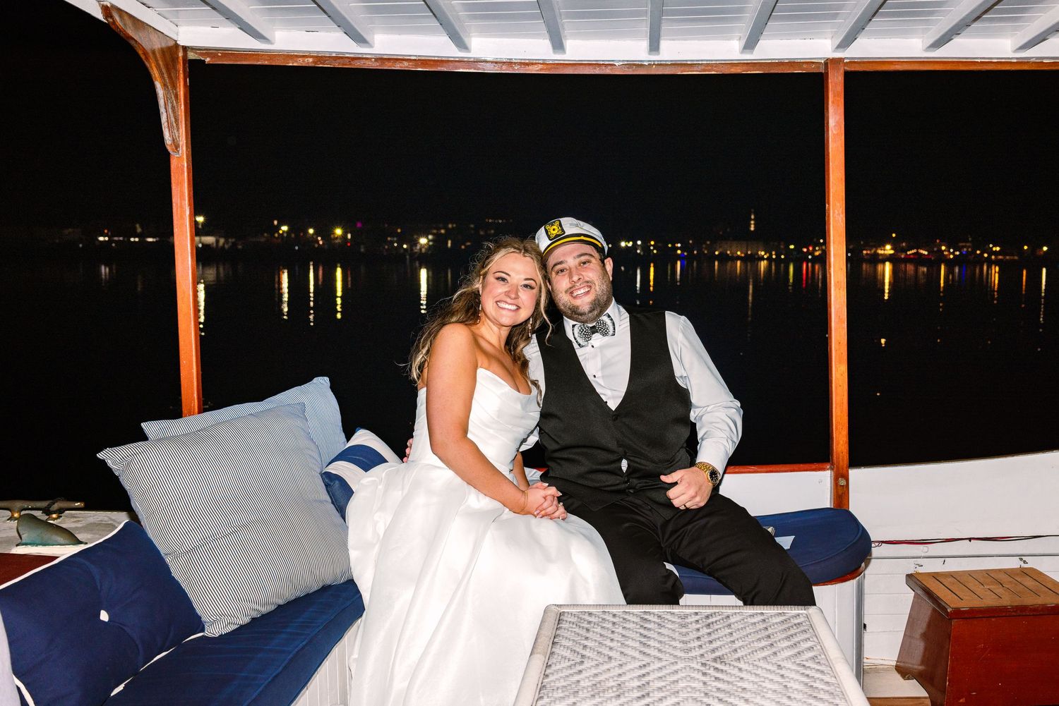 A bride and groom have a boat send-off at the end of the reception and pose for flash portraits taken at The Regatta Place in Newport RI