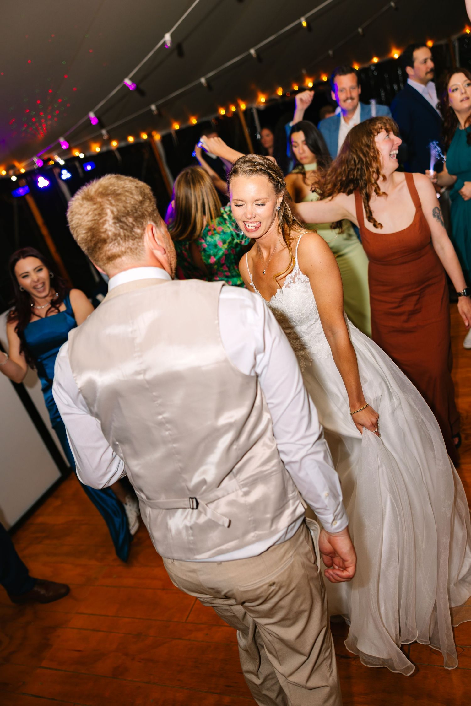 Bride and groom dancing at a wedding reception with string lights overhead at tented outdoor wedding reception in New London County CT