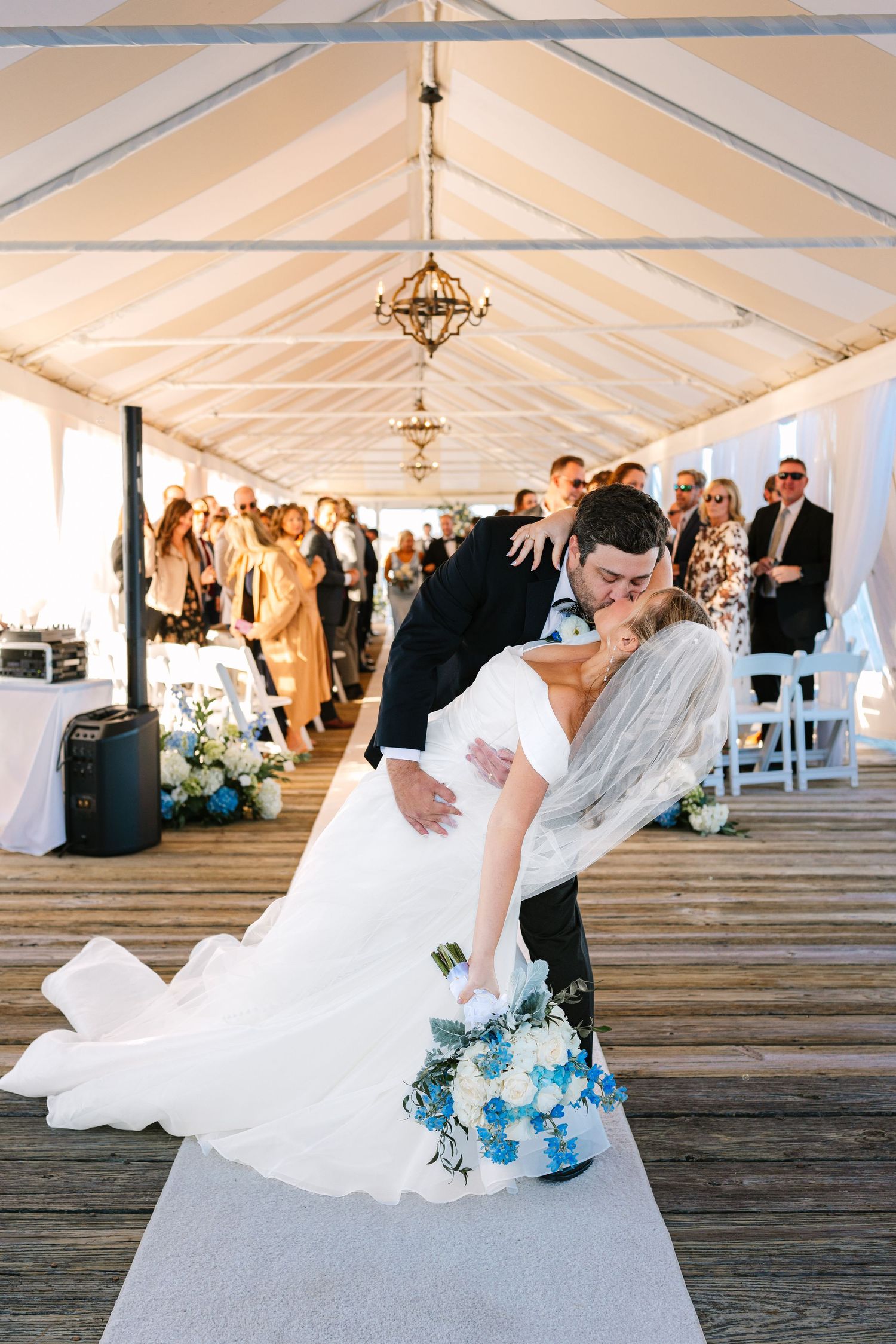 Bride and groom romantically dip-kiss exiting their tented outdoor ceremony at The Regatta Place in Newport, Rhode Island