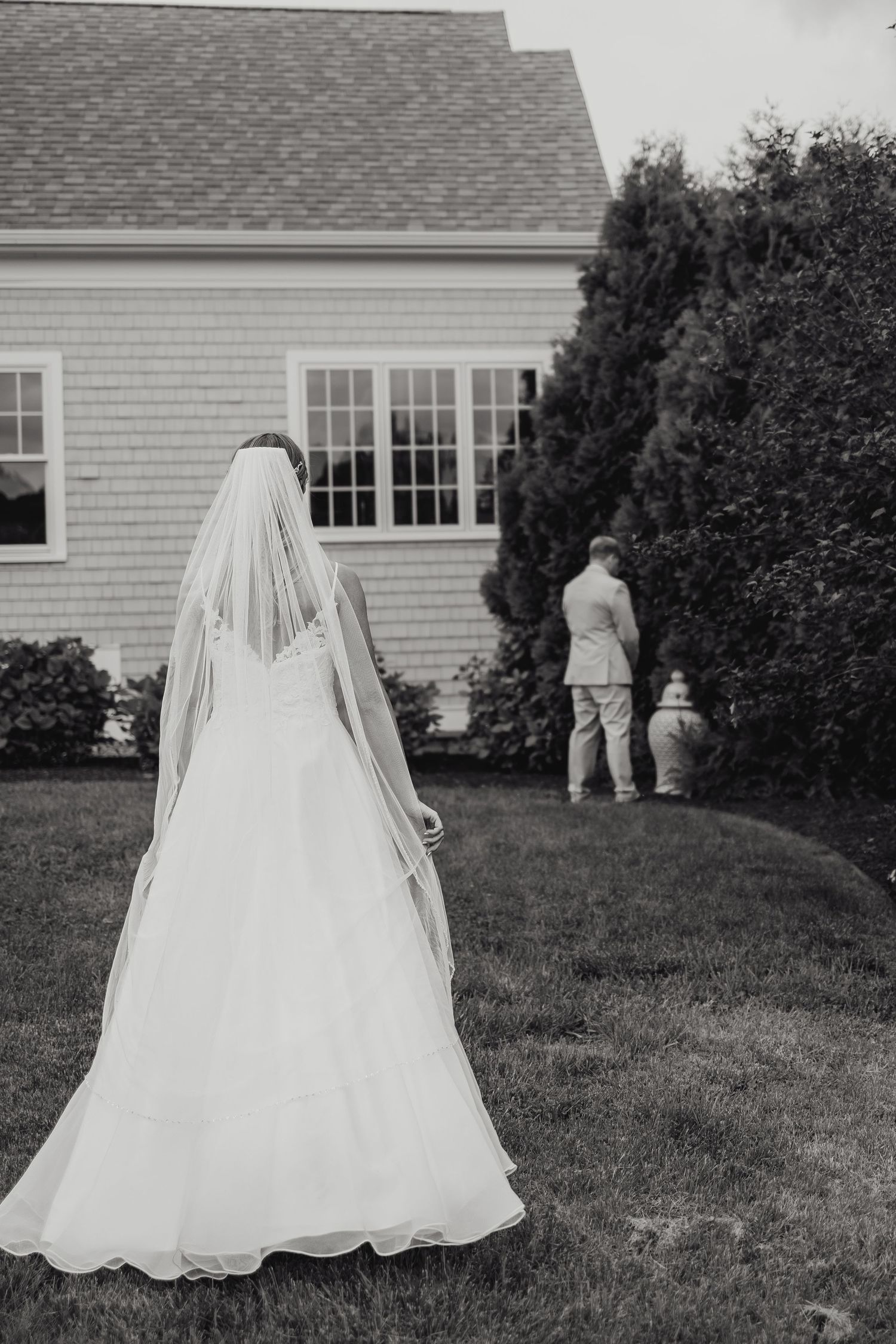 A black and white portrait of bride and groom during their first look at an outdoor backyard wedding in New London County Connecticut