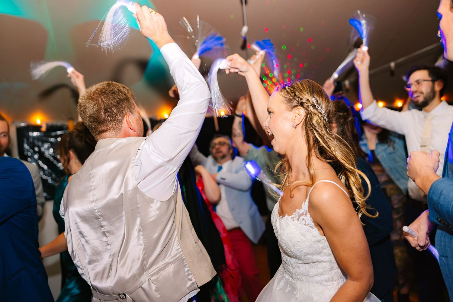 Wedding reception dance party with high energy celebration and colorful lights on a crowded dance floor at a backyard wedding in Connecticut
