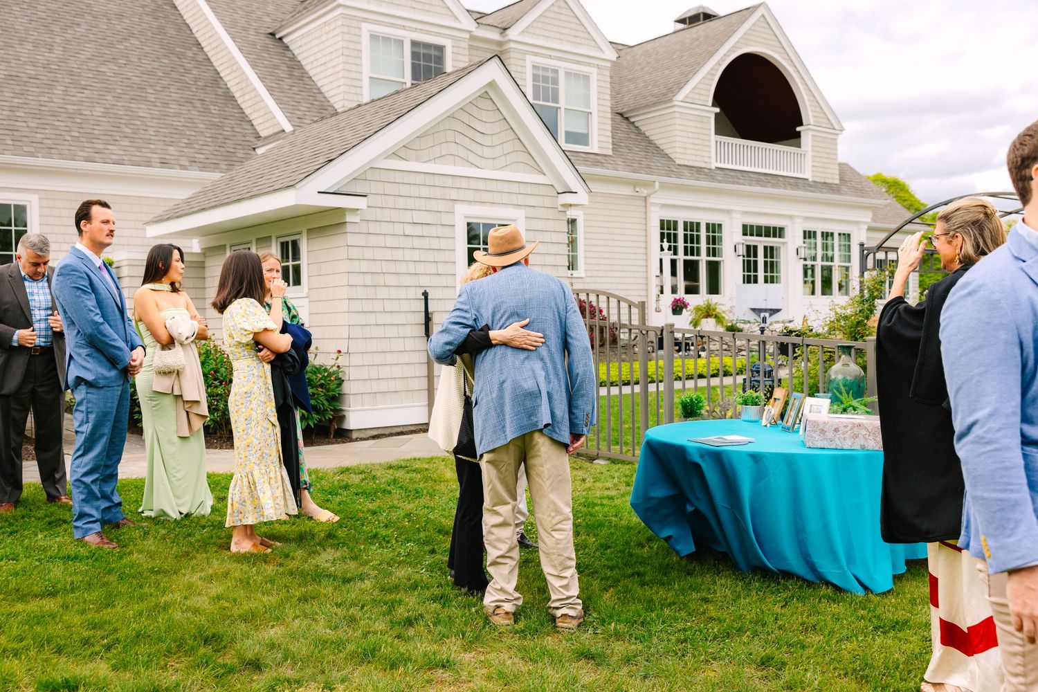 A series of social gathering photos outside a white house with lawn decorations and guests mingling at an outdoor party.