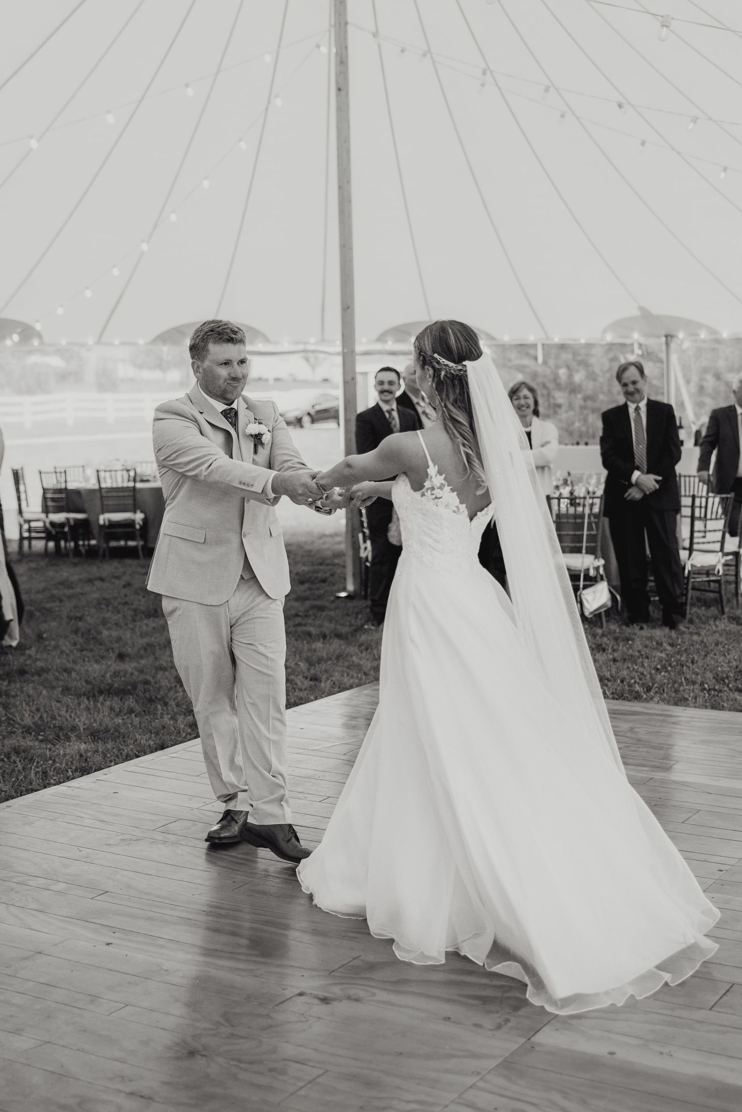 Black and white photo sequence of a couple dancing at their wedding reception on an outdoor dance floor under a tent.