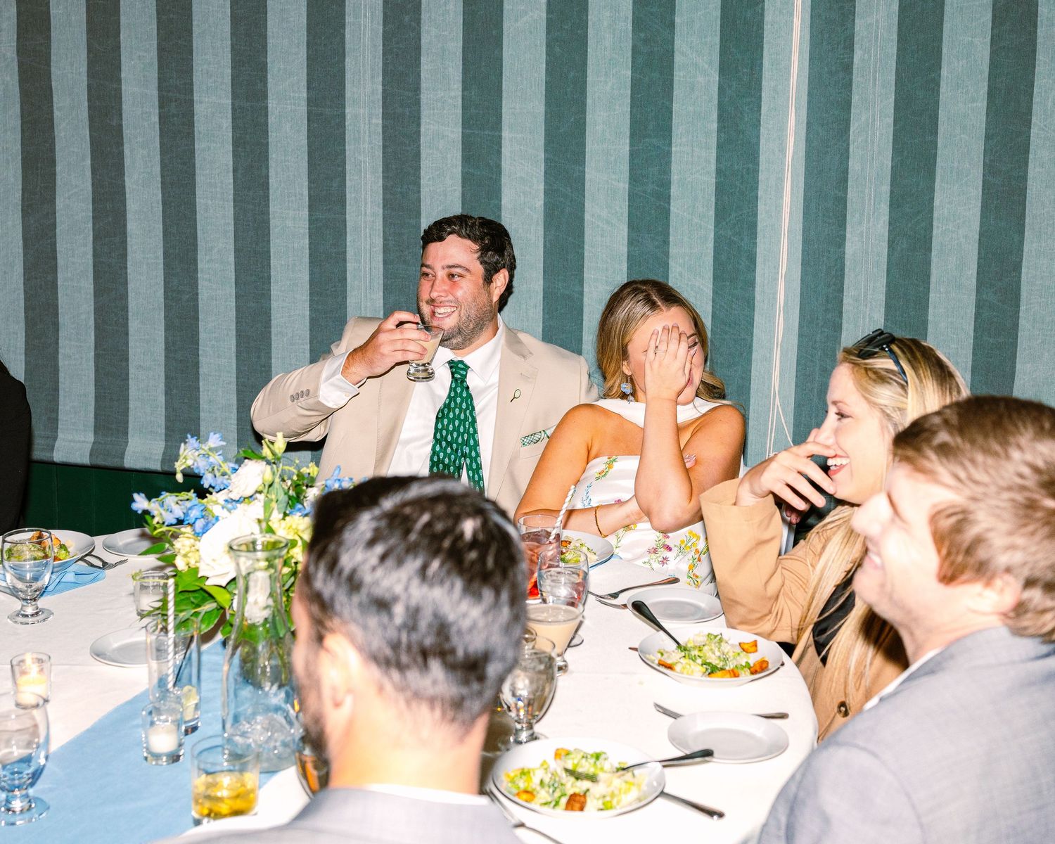 A group of people seated at a long banquet table with food and drinks during what appears to be a celebration.