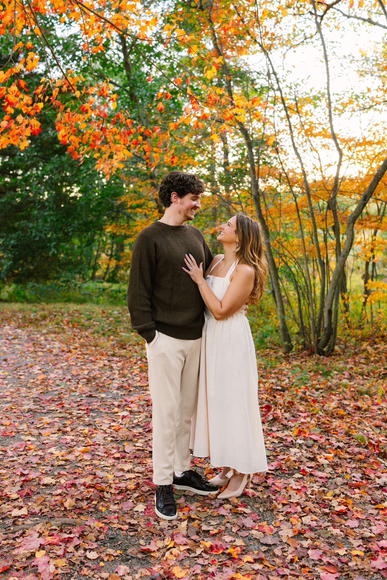 A couple tenderly poses for engagement photos during fall foliage at Arnold Arboretum in Boston Massachusetts
