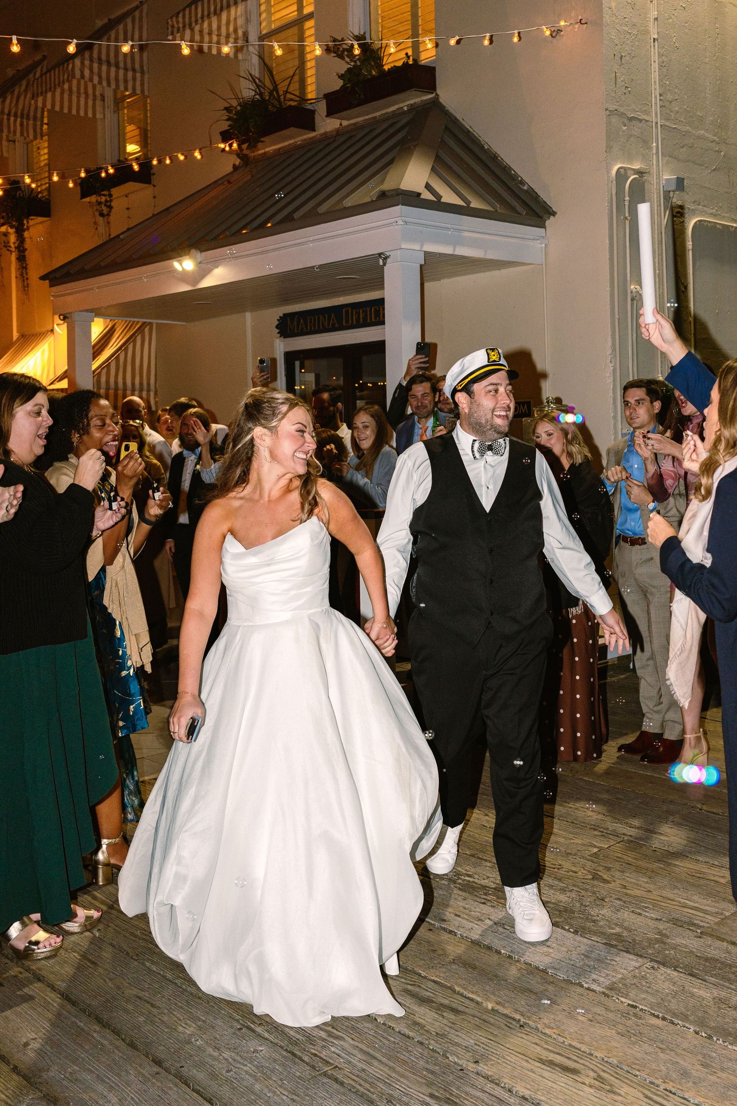 A bride and groom cheerfully have a grand exit using bubbles at The Regatta Place in Newport, Rhode Island wedding venue
