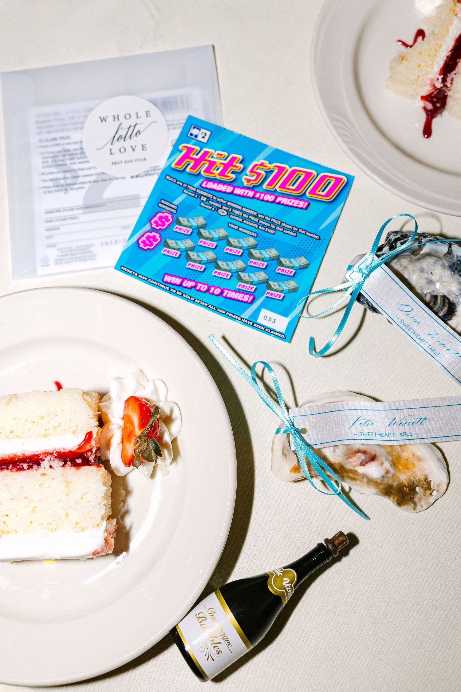 White plates with partially eaten cake and blue lottery tickets scattered on a reception table during wedding at The Regatta Place in RI