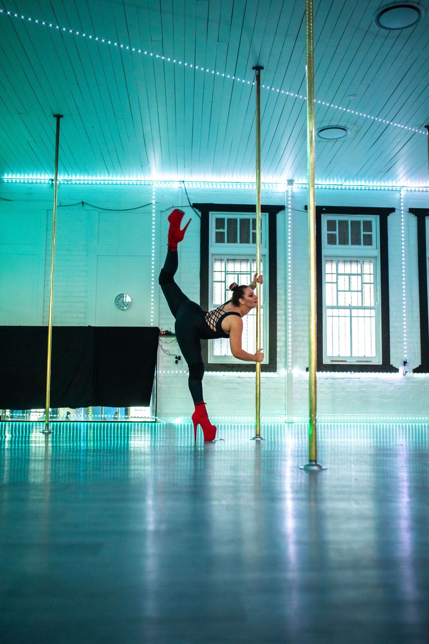 Professional pole dancer performing a dynamic movement during a pole fitness showcase