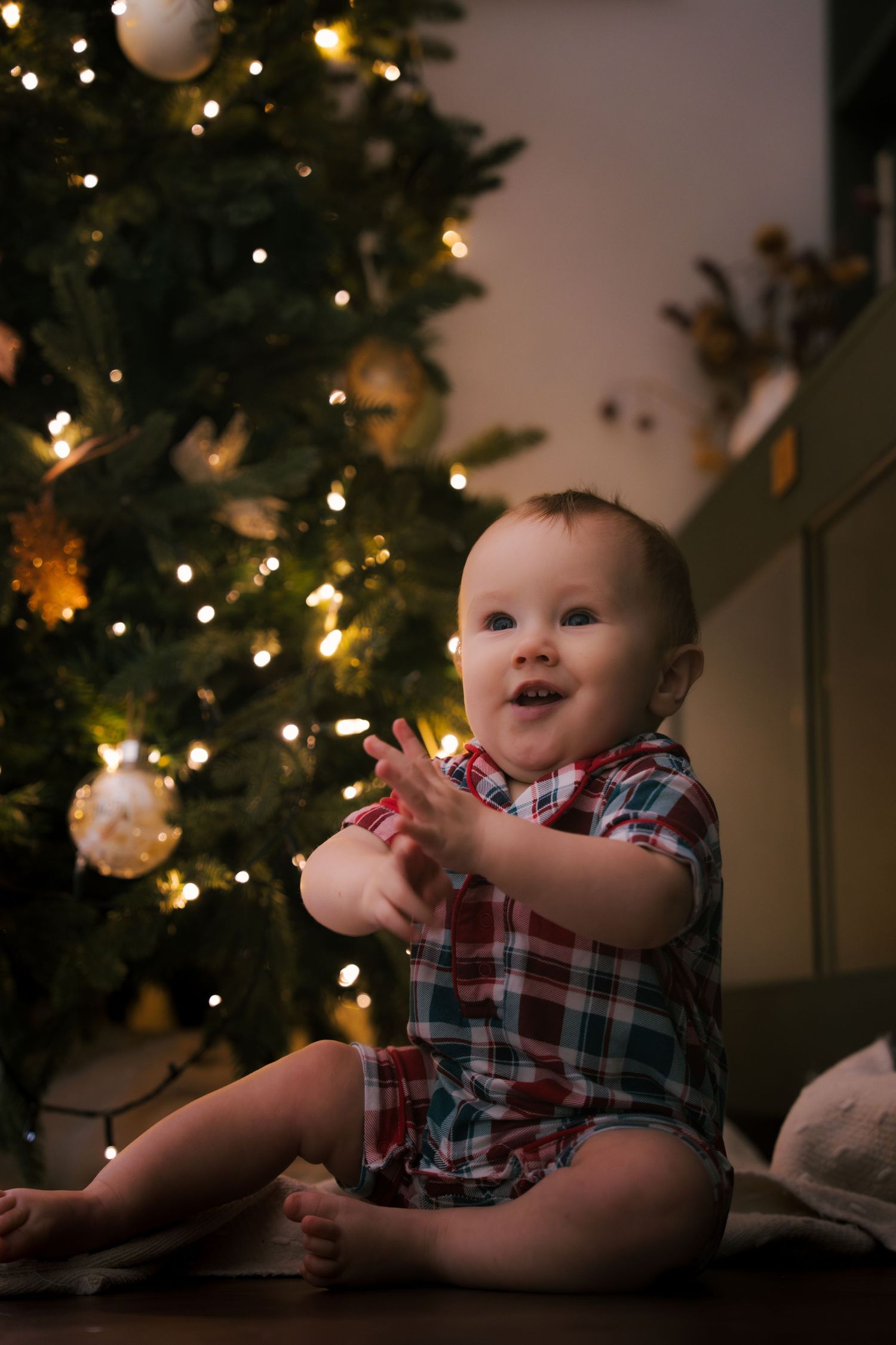 Toddler enjoying an indoor Christmas photography session with festive holiday décor.
