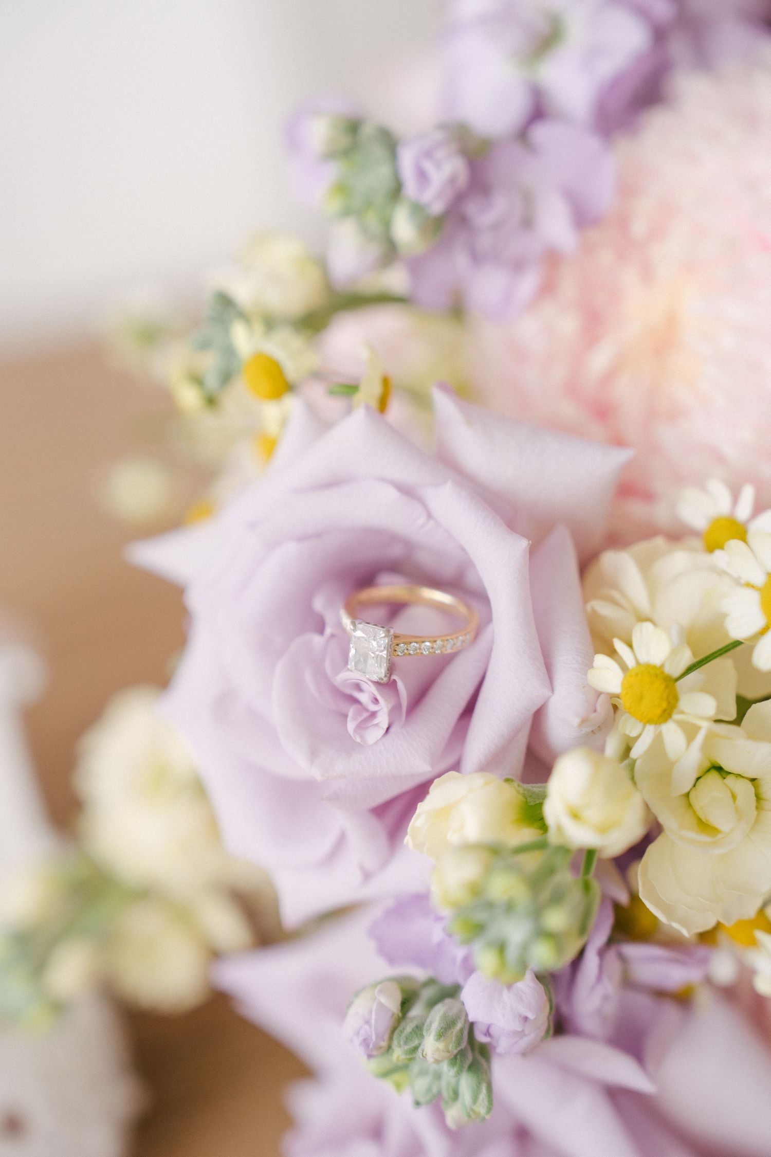 Wedding rings carefully placed inside a flower for a creative wedding detail photograph.