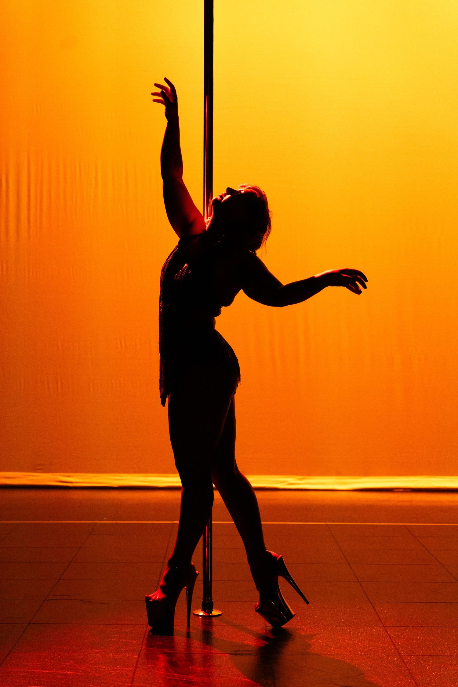 Competitor showcasing strength and artistry at a pole dance event.