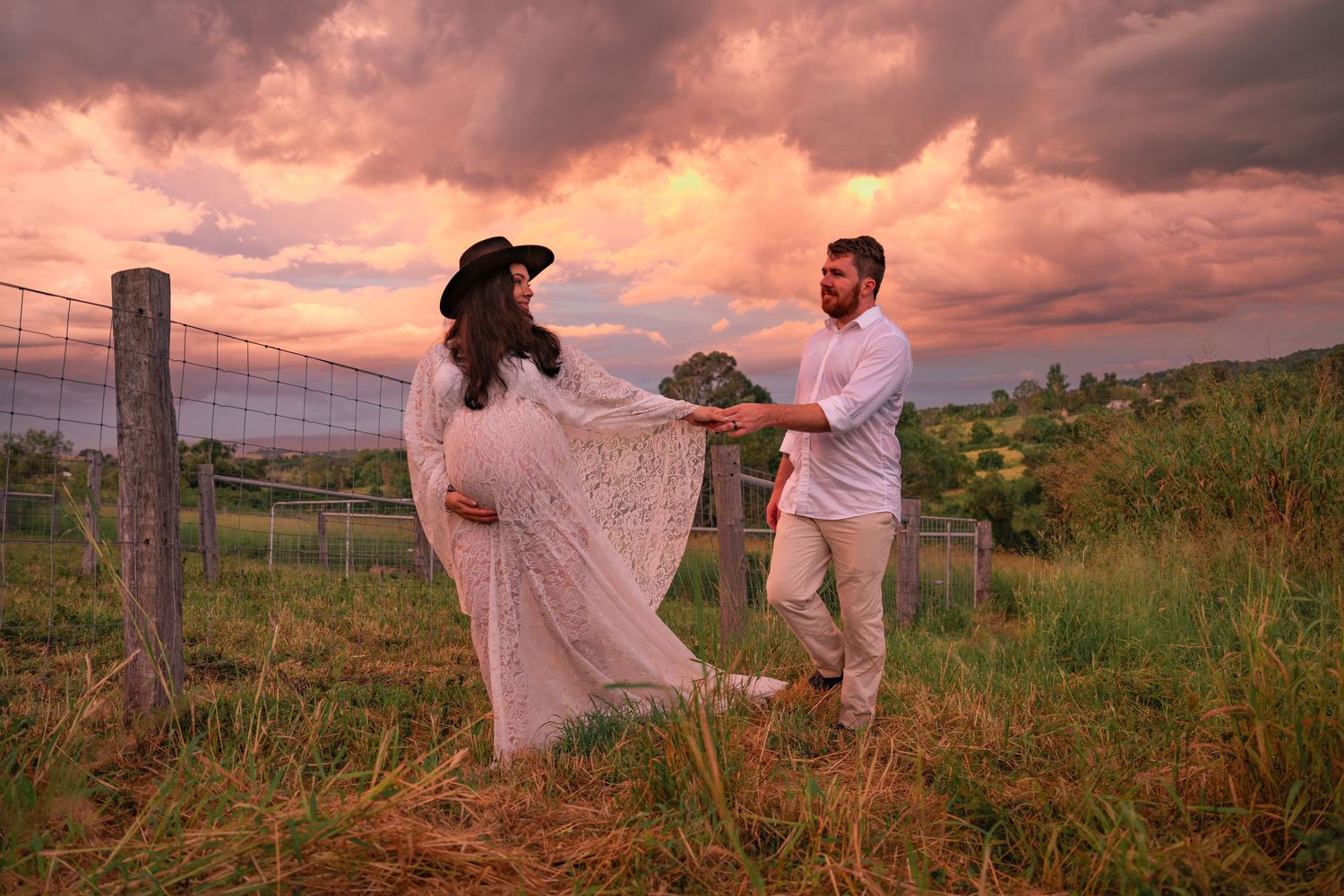 Excited couple sharing a moment during their outdoor maternity session